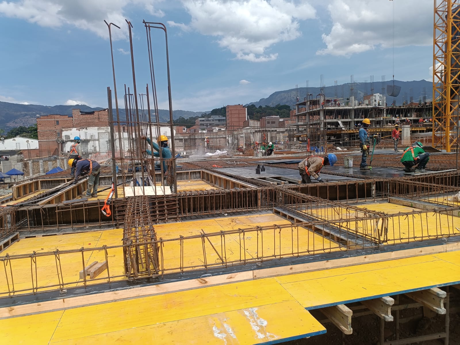 Frente de trabajo en losa con tableros fenólicos amarillos y armado de acero